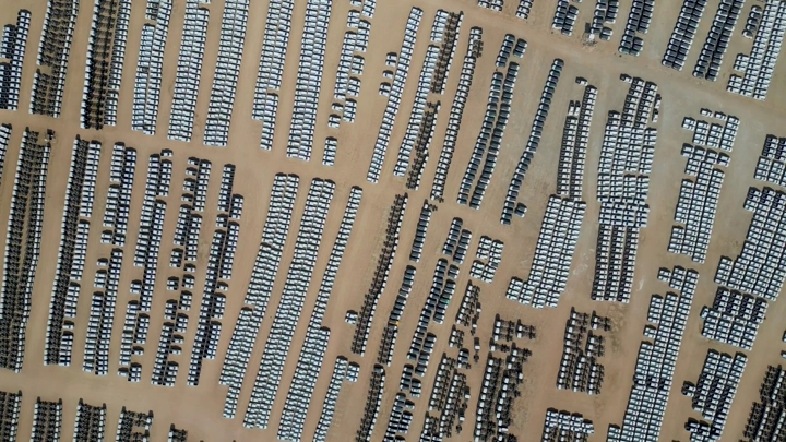 سيارات مصطفة في ساحة كبيرة، لقطة جوية.