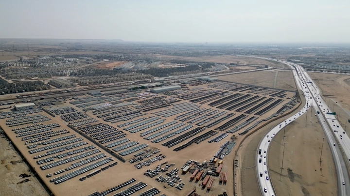 منظر جوي لموقف سيارات كبير في منطقة صحراوية، لقطة من طائرة الدرون.