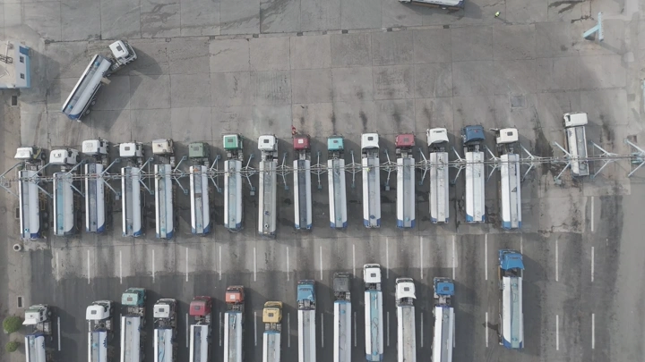 شاحنات مياه مصطفة في موقف كبير، لقطة جوية.