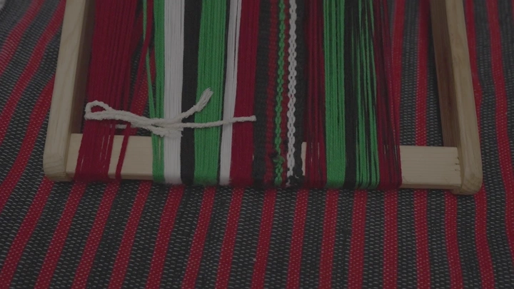 نسيج السدو الملون على نول خشبي، لقطة قريبة.