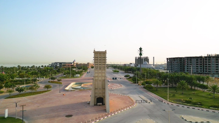 الواجهة البحرية في الدمام عند الغروب مع طيور تحلق في السماء، لقطة جوية.