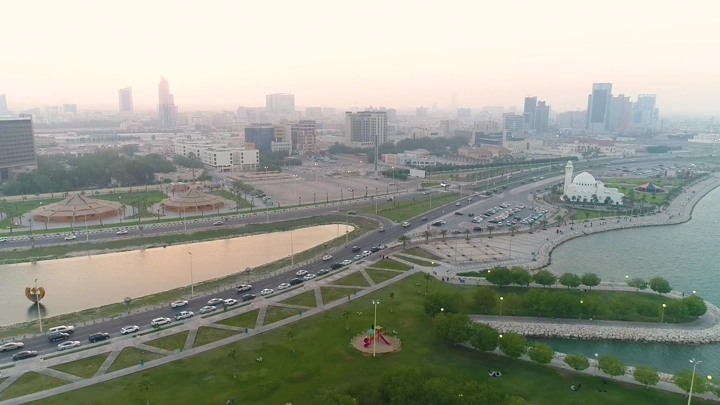 منظر جوي لمدينة الخبر عند الغروب، يظهر برج المياه والواجهة البحرية.