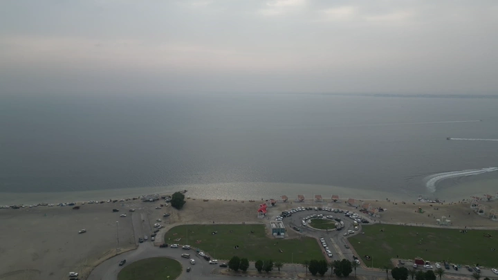 شاطئ الهاف مون مع سيارات ومباني، لقطة جوية.