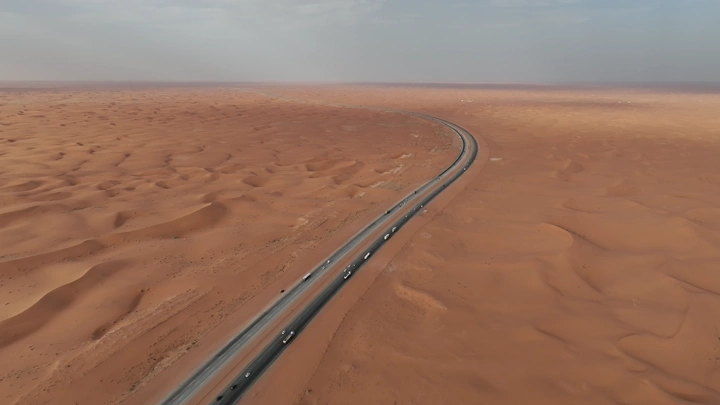 طريق يمتد عبر الصحراء في الدمام نهاراً، لقطة جوية.