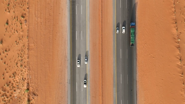 طريق سريع في الصحراء مع سيارات، لقطة جوية.