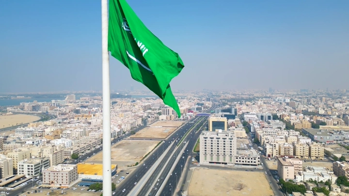 علم السعودية يرفرف فوق دوار العلم في جدة، لقطة جوية.