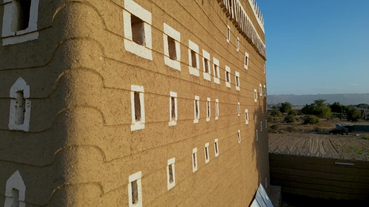 جانب قصر طيني في نجران تحت ضوء الشمس، لقطة من زاوية قريبه.