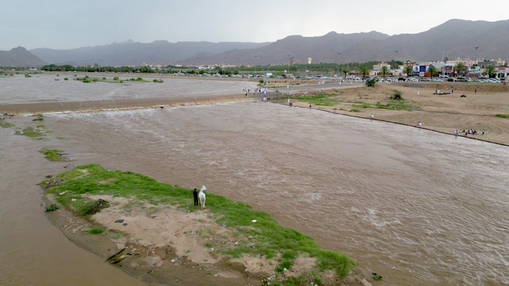 سيل المطر في نجران، لقطة جوية تظهر المياه والمنازل في الخلفية.