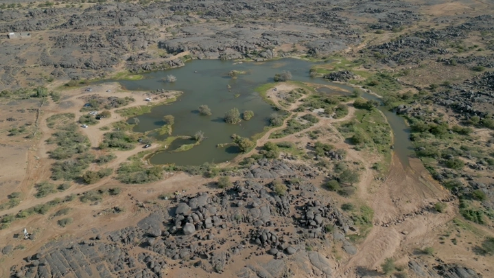 منظر جوي لبئر عسكر في نجران، يظهر التضاريس الصخرية والمياه المحيطة.