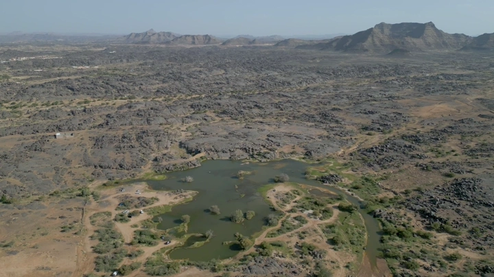 منظر جوي لبئر عسكر في نجران، يظهر التضاريس الصخرية والمياه المحيطة.