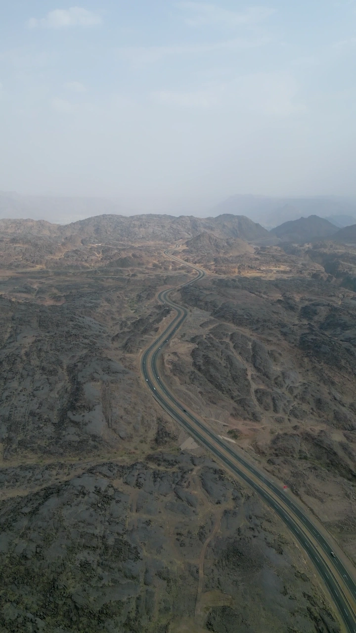 طريق جبلي في نجران يمتد عبر التضاريس الوعرة، لقطة جوية.