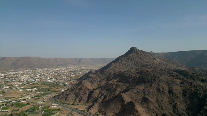 جبل يطل على مدينة نجران في يوم مشمس، لقطة جوية.