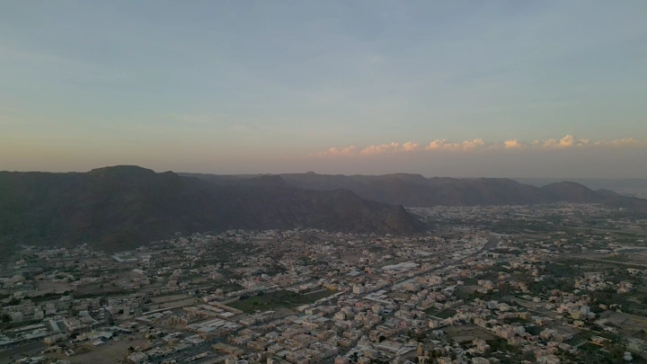 مدينة نجران محاطة بالجبال عند الغروب، لقطة جوية.