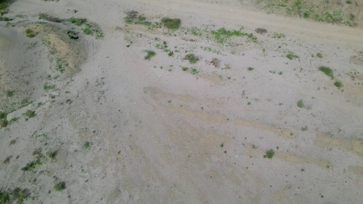 أرض جافة مع بعض النباتات الخضراء في جيزان، لقطة جوية.