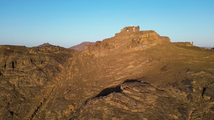 تلال صخرية مع مبنى قديم في المدينة المنورة، لقطة جوية.