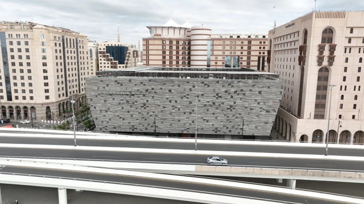 مبنى حديث في المدينة المنورة مع طريق سريع، لقطة جوية.