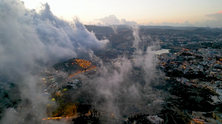 مدينة أبها مغطاة بالضباب عند الغروب، لقطة جوية.