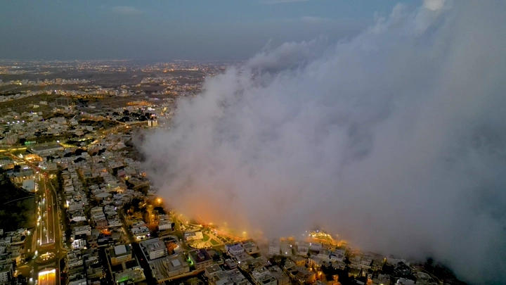 مدينة أبها مغطاة بالضباب في المساء، لقطة جوية.