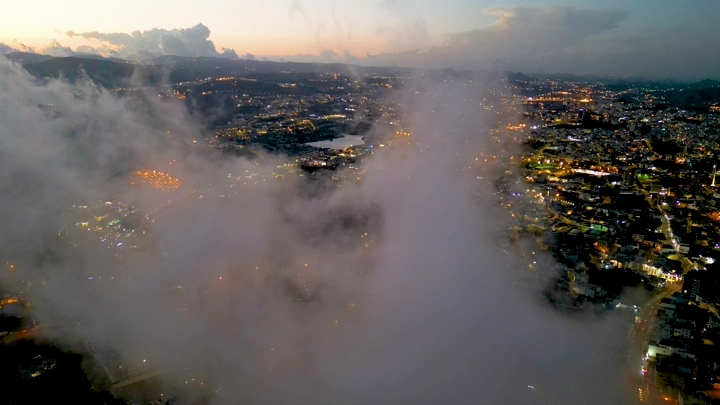 مدينة أبها مغطاة بالضباب عند الغروب، لقطة جوية.