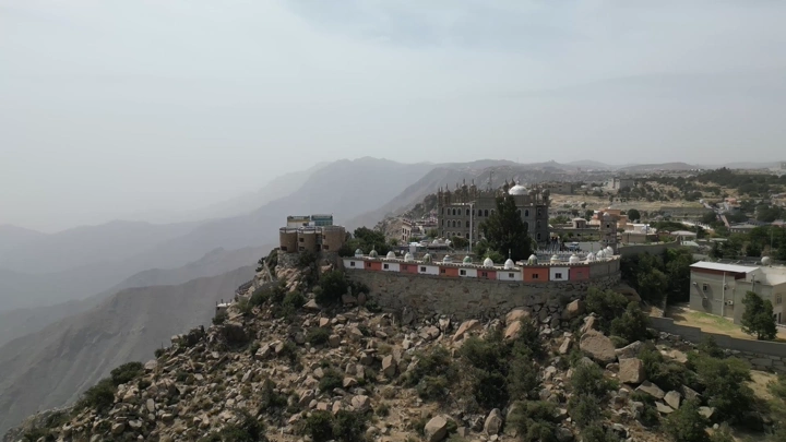 قرية المقر السياحية في النماص، لقطة جوية تظهر المباني والمناظر الطبيعية.