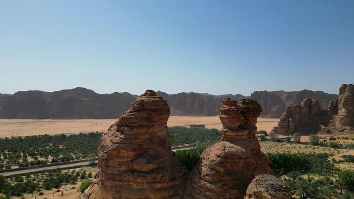 تكوينات صخرية في جبال العلا تحت سماء زرقاء، لقطة درون.