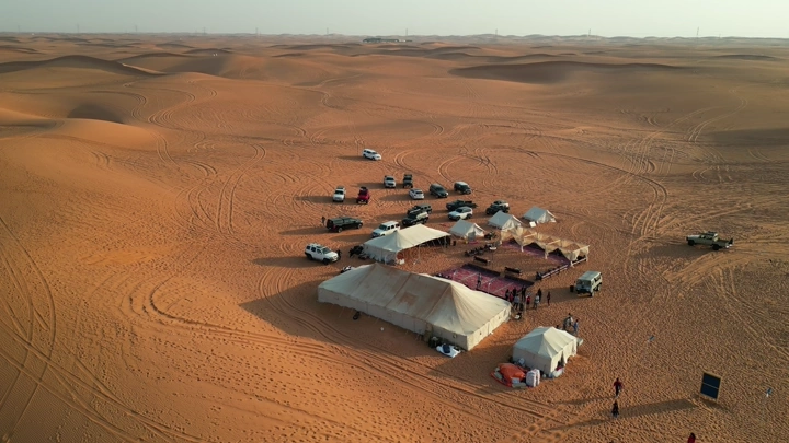 تخييم في صحراء النفود مع خيام وسيارات، لقطة جوية.
