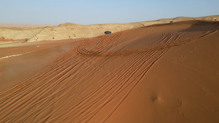 سيارة تطعيس في الصحراء الرملية، لقطة جوية.