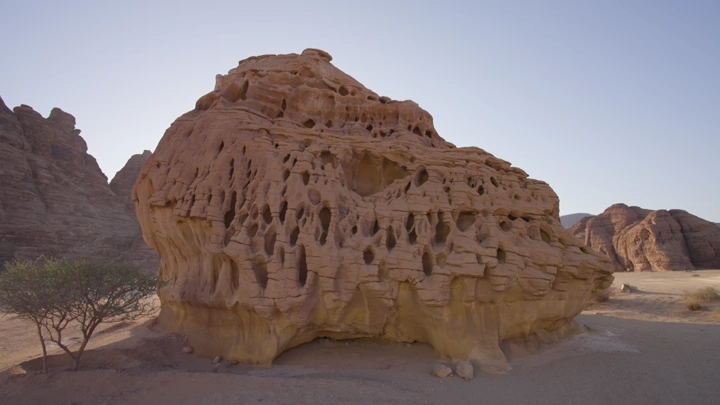 تكوين صخري في جبال العلا تحت السماء الزرقاء، لقطة نهارية.