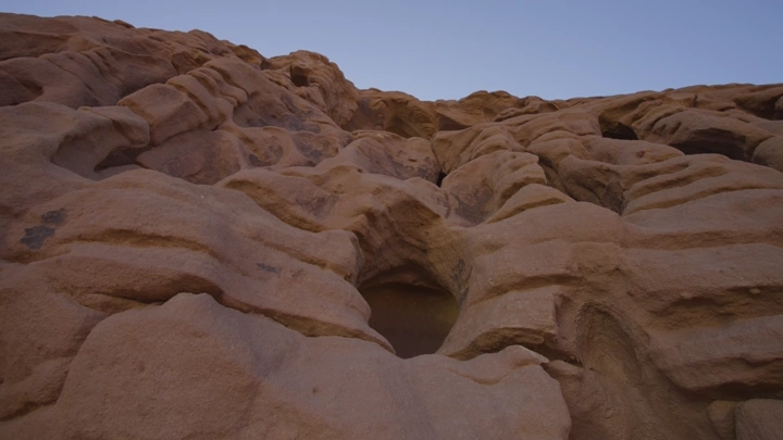 تكوينات صخرية في جبال العلا تحت سماء زرقاء، لقطة منخفضة.