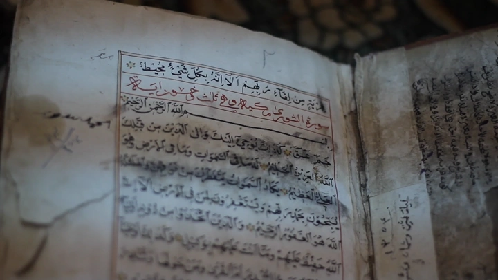 صفحة من القرآن الكريم بخط عربي قديم، لقطة مقربة.