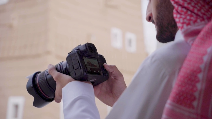 شخص يصور قصر الإمارة التاريخي في نجران، لقطة قريبة.