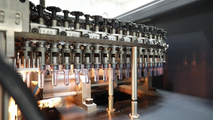 آلة تعبئة زجاجات في مصنع مياه، لقطة مقربة.