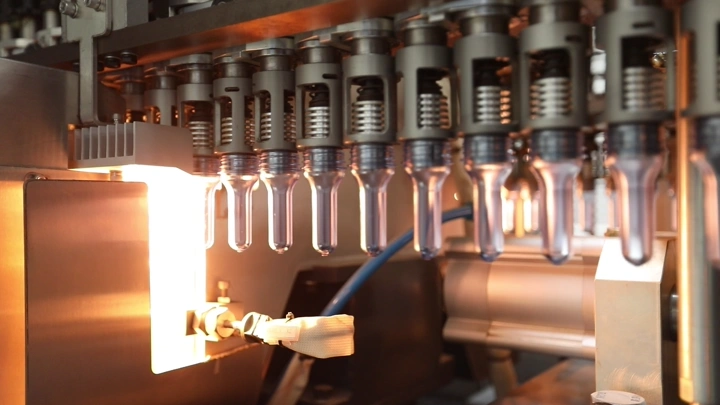 آلات تعبئة زجاجات في مصنع مياه، لقطة مقربة.