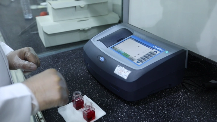 جهاز تحليل مختبر على طاولة مع عينات سائلة، لقطة مقربة.