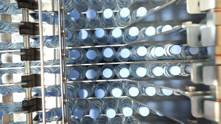 زجاجات مياه مرتبة في مصنع، لقطة من الأعلى.