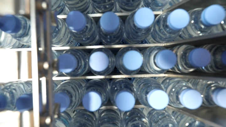 زجاجات مياه مرتبة في مصنع، لقطة من الأعلى.