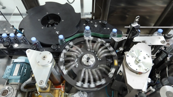 آلة تعبئة زجاجات مياه في مصنع، لقطة علوية.