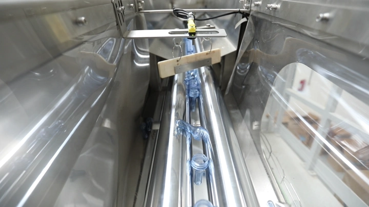 خط إنتاج زجاجات مياه في مصنع، لقطة داخلية.