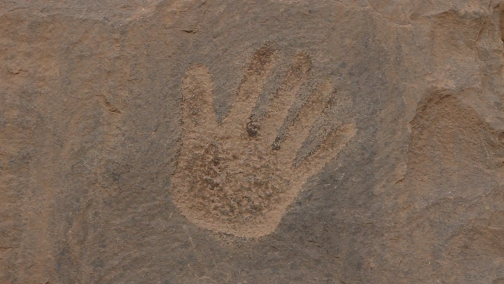 نقش يد على صخرة في الأخدود نجران، لقطة قريبة.