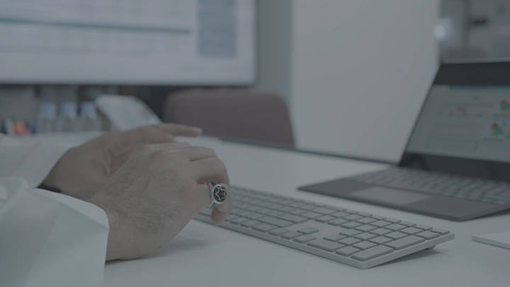 رجل يعمل على لوحة مفاتيح في مكتب حديث، لقطة قريبة.