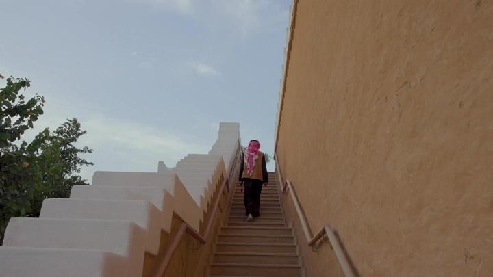 رجل يصعد درج في منتزه البجيري، الدرعية، لقطة من الخلف.