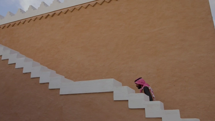 رجل يصعد درج في منتزه البجيري، الدرعية، لقطة جانبية.