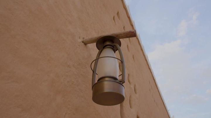 فانوس تقليدي على جدار طيني في منتزه البجيري، لقطة قريبة.