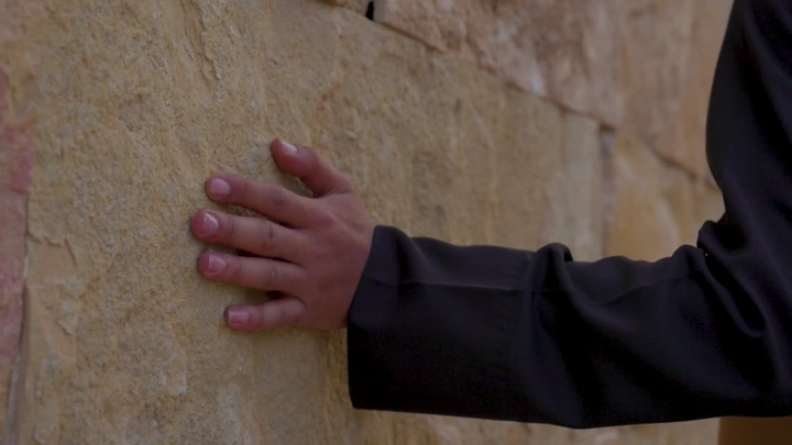 يد تلمس جدار حجري، لقطة مقربة.