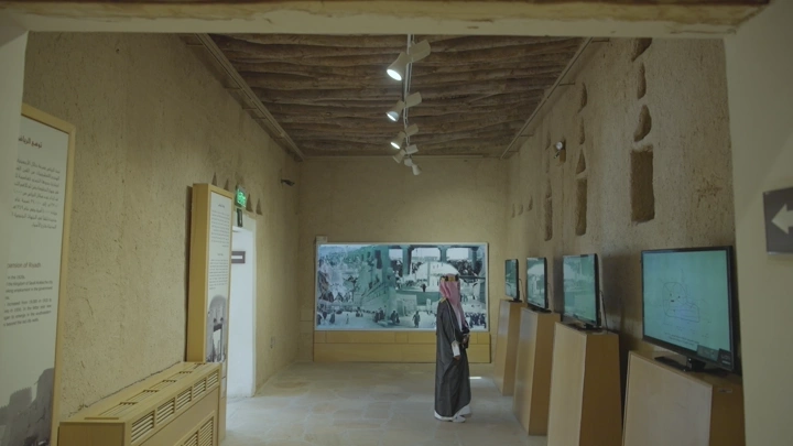 زائر في معرض داخل قصر المصمك بالرياض، لقطة داخلية.