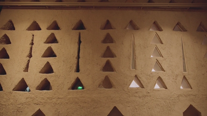 جدار طيني مع نوافذ مثلثة في قصر المصمك، لقطة قريبة.