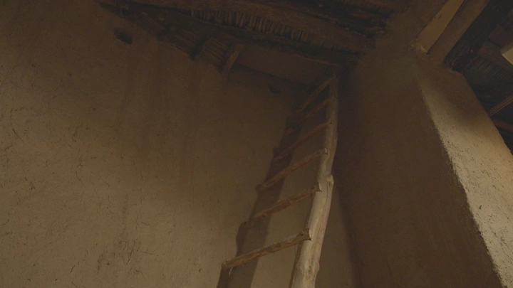 درج خشبي في بيت طيني، لقطة داخلية.