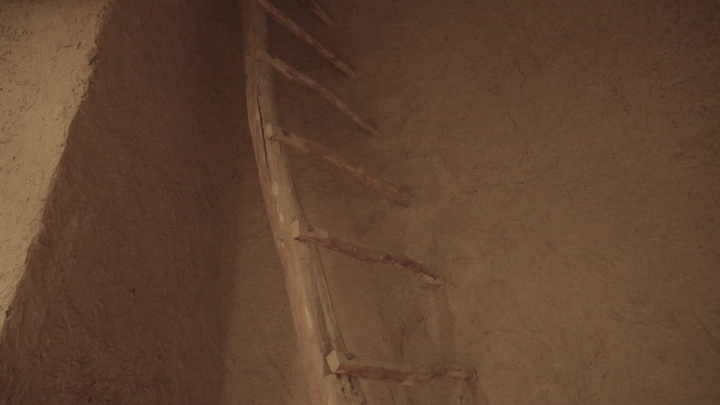 درج خشبي في بيت طيني، لقطة داخلية.