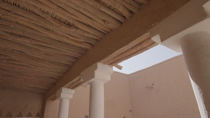 أعمدة وسقف خشبي في قصر المصمك بالرياض، لقطة من الأسفل.