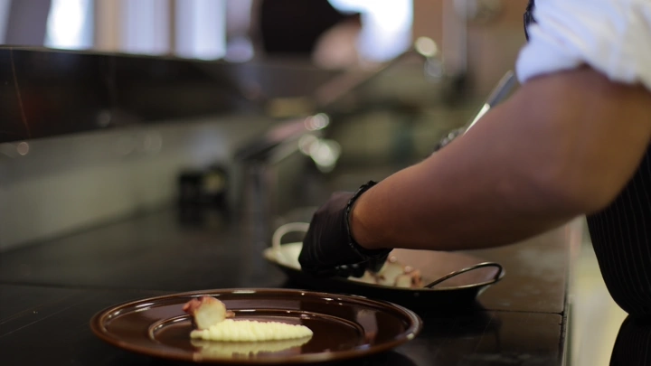 تحضير طبق أخطبوط مشوي في مطعم، لقطة مقربة.